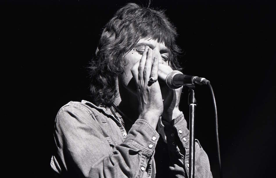 Mick suona l'armonica durante una performance negli anni '70  (Photo by Robert Knight Archive/Redferns)