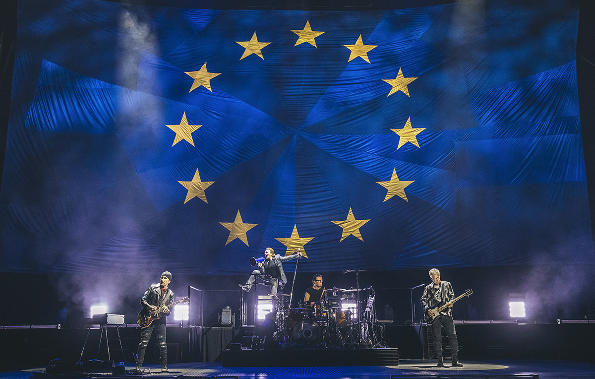 Gli U2 a Milano con la bandiera dell’UE: «Grazie per la tolleranza che mostrate ai rifugiati»